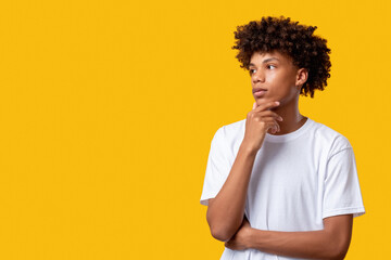 Pensive black teenager. Think idea. Confused young african student isolated on orange copy space. Make decision. Social tolerance. Advertising background