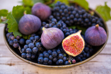 Ripe grapes and figs on a vintage plate.