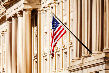 US flag over classical government building with columns in Washington, DC - obrazy, fototapety, plakaty