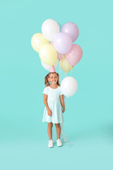 Little girl with balloons and birthday hat on color background