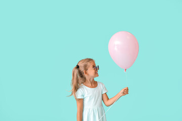 Little girl with balloon on color background