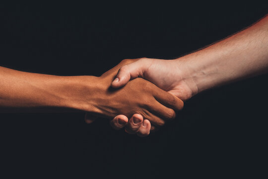 Black lives matter. Human tolerance. Unrecognizable multicolor male hands shaking isolated on dark copy space. Ethnic friendship. No racism. Races agreement