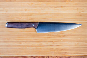 Kitchen large chef's knife on the wooden cutting board