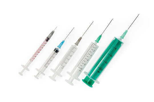Different disposable syringes with needles on white background, top view