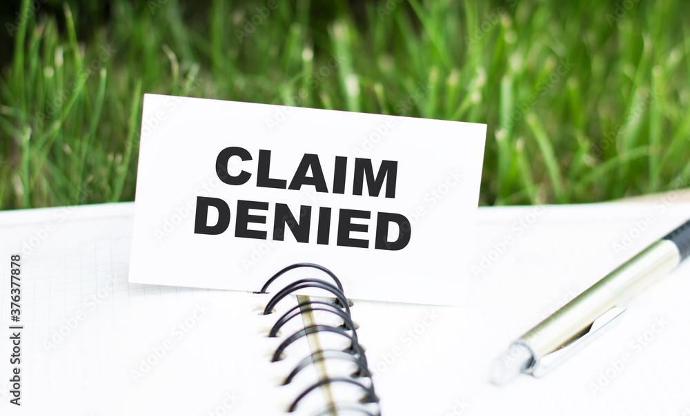 Poster a card with text claim denied lying on a notebook