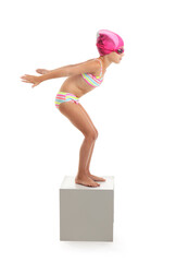 Little girl in start position on swimming block against white background