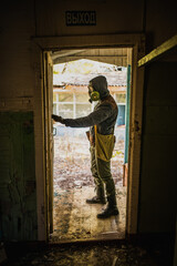 Fototapeta premium cosplay on a Stalker, a man in a gas mask stands with a machine gun
