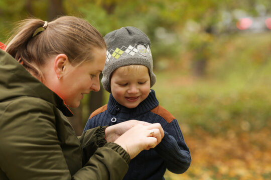 Mother and son in autumn park outdoor. Mom is care of her son. Famity activity in nature
