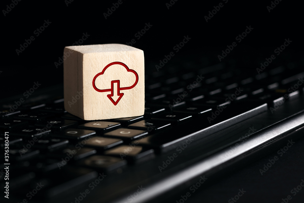 Poster cloud computing download icon on wooden cube with computer keyboard. remote download technology conc