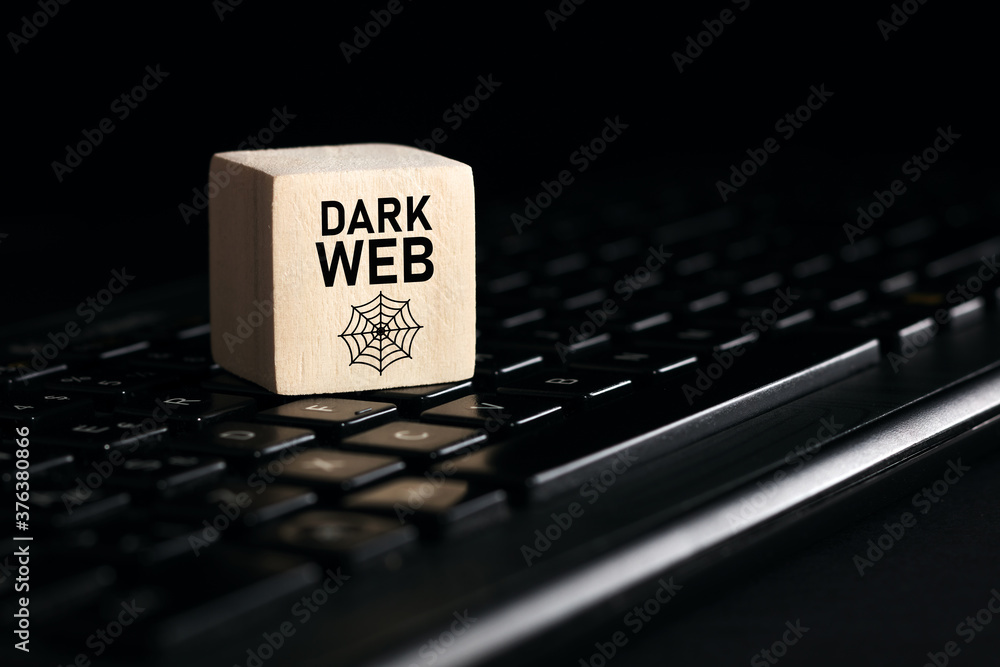 Poster the word dark web on wooden cube with computer keyboard. cyber crime and illegal outlets in cyberspa