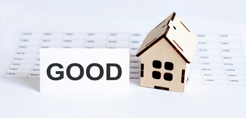 Closeup of house wooden model with blank for text GOOD on chart background.