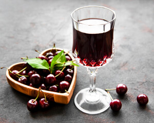 Cherry liqueur in a glass and fresh fruits
