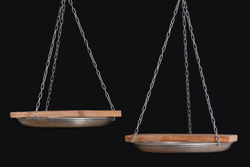 Balance scales and wooden coasters on black background, close up. Copy space