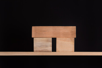 Wooden blocks on wooden shelf. Stand on black background. Mockup