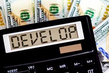 Calculator with text DEVELOP on the dollars. Business, finance conceptual.