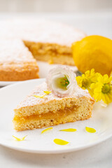 A piece of pie with lemon curd filling, decorated with flowers. Vertical photo.