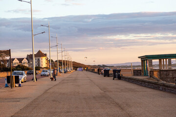 people walking on the beach at sunset