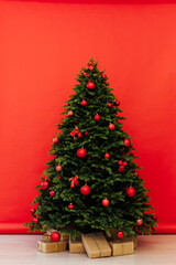 Interior Christmas tree with gifts for new year decor winter red background