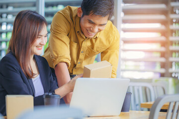 Friendly Asian colleagues having conversation in office, Packaging design creative designer workers discussing work with laptop. Coworker collaboration concept