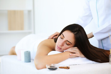 Obraz na płótnie Canvas Attractive brunette relaxing with her eyes closed and enjoying spa treatments.