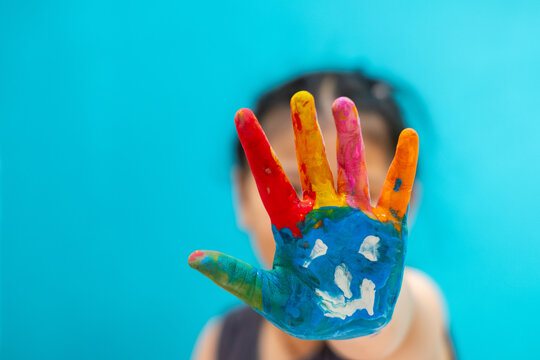 kid paint the water on the hand. Focus at baby hand.