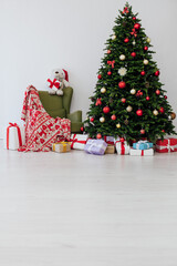 The interior of the white room is a green Christmas tree with red gifts for the new year holiday decor