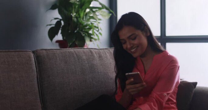 Beatutiful woman smiling while reading a text on her phone	