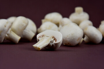 Pile of white champignon mushrooms stock images. Mushrooms isolated on a brown background with copy space for text. Fresh white champignon mushrooms stock photo