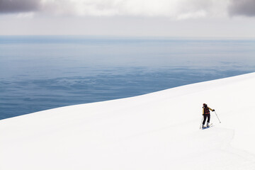 A skier taking a break, skiing very close to the Atlantic ocean, Iceland