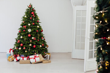 The interior of the room is a green Christmas tree with red gifts for the new year decor of the winter holiday home