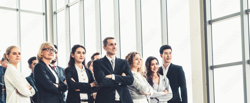 Wall mural Successful business people standing together showing strong relationship of worker community. A team of businessman and businesswoman expressing a strong group teamwork at the modern office.