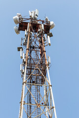Telecommunication equipment on a blue sky background. Directional antenna for mobile phones. The concept of wireless communication. Tower with a communication repeater antenna. Repeater