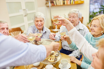 Group of seniors celebrates birthday with white wine