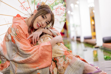 Young woman in traditional Japanese kimono with an umbrella  and looking at camera, Japanese...
