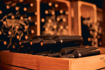 Dusty bottles of red wine in wooden crate