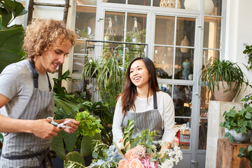 Young florist and colleague tie bouquet