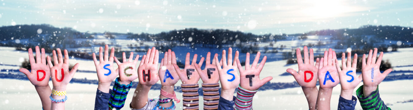 Children Hands Building Colorful German Word Du Schaffst Das Means You Can Do It. Snowy Winter Background With Snowflakes