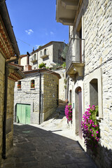 A small road crosses the old buildings of Catelmezzano, a rural village in the Basilicata region, Italy.
