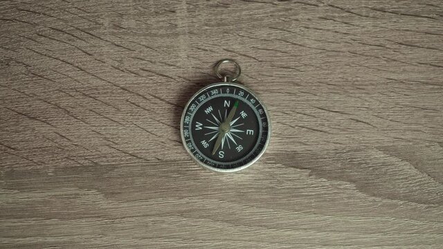compass is on a wooden table. camera zoom
