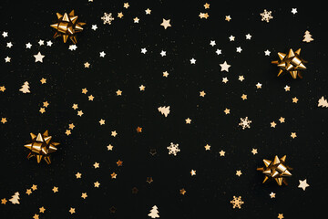 Festive dark background with many golden Christmas and New Year decorations and stars.