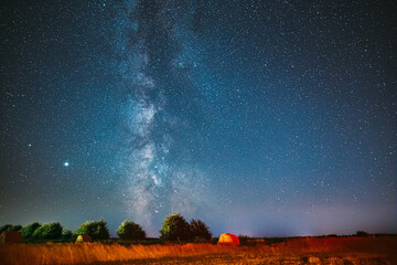 Milky Way Galaxy In Night Starry Sky Above Haystack In Summer Agricultural Field. Night Stars Above Rural Landscape With Hay Bale After Harvest. Agricultural Concept