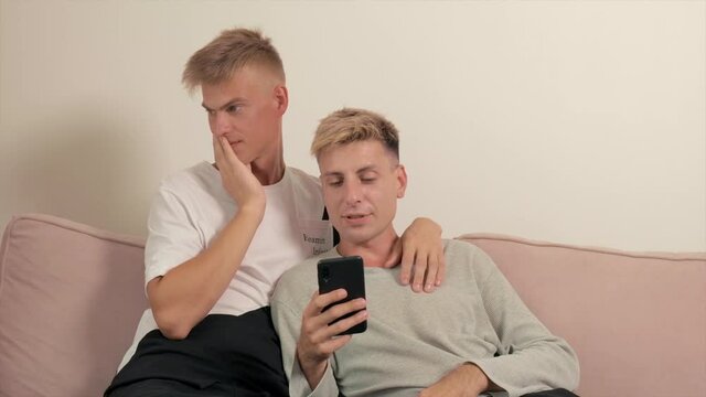 Gay couple video link Leah together on the couch. Two guys love a friend. Relaxing at home together. Look with loving eyes.