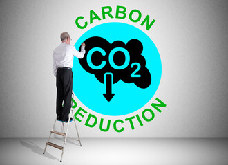 Carbon reduction concept drawn by a man on a ladder