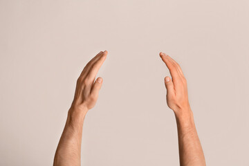 Closeup view of male hands holding something on light background, mockup for design