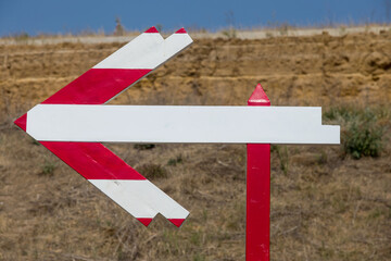 Wooden road sign on the road. Pedestrian route arrow sign direction sign. A wooden arrow indicates the route of movement with a place for an inscription. Follow the wooden arrow. Direction of arrow