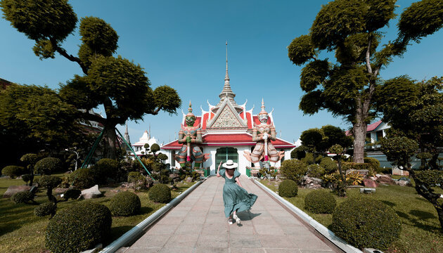 Young Asian woman is enjoy sightseeing and traveling at Wat Arun temple in Bangkok, Thailand.