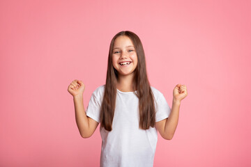 Emotions of happiness and victory. Small child expresses joy and raises her fists up