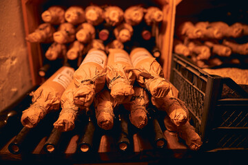 Bottles of wine packed in craft paper in the cellar