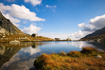 Long exposure closeup of a mountain lake with a reflection on a cloudy autumn day