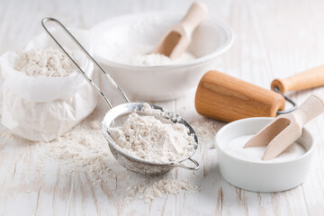 Spelt flour, sugar with baking ingredients and kitchen utensils